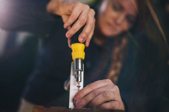 Person schraubt Holzlatten zusammen